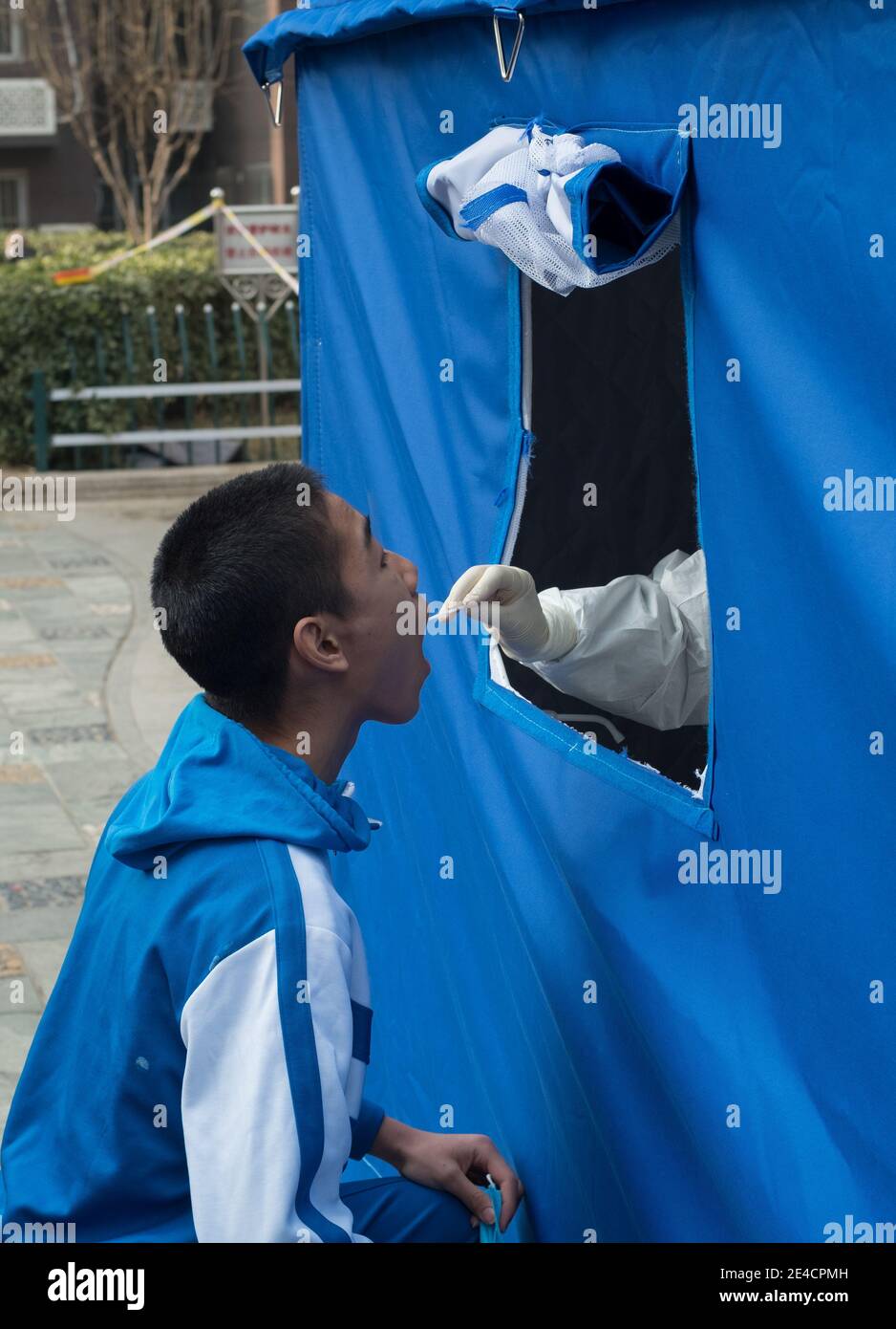 Un travailleur médical prélève un écouvillon auprès d'un garçon pour des tests d'acide nucléique, à la suite de nouveaux cas de coronavirus à Beijing, en Chine, le 23 janvier 2021. Banque D'Images