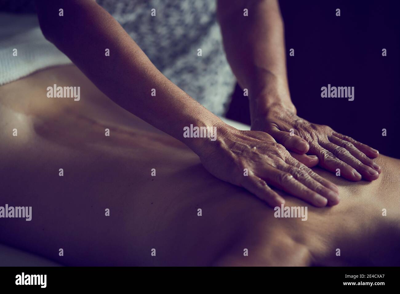 Gros plan des mains d'une masseuse professionnelle sur le dos d'une femme recevant un massage corporel intégral. Banque D'Images