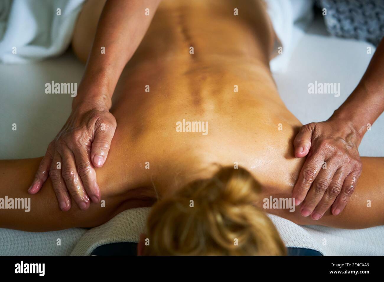 Une femme recevant un massage complet d'huile de corps par un masseuse professionnelle Banque D'Images