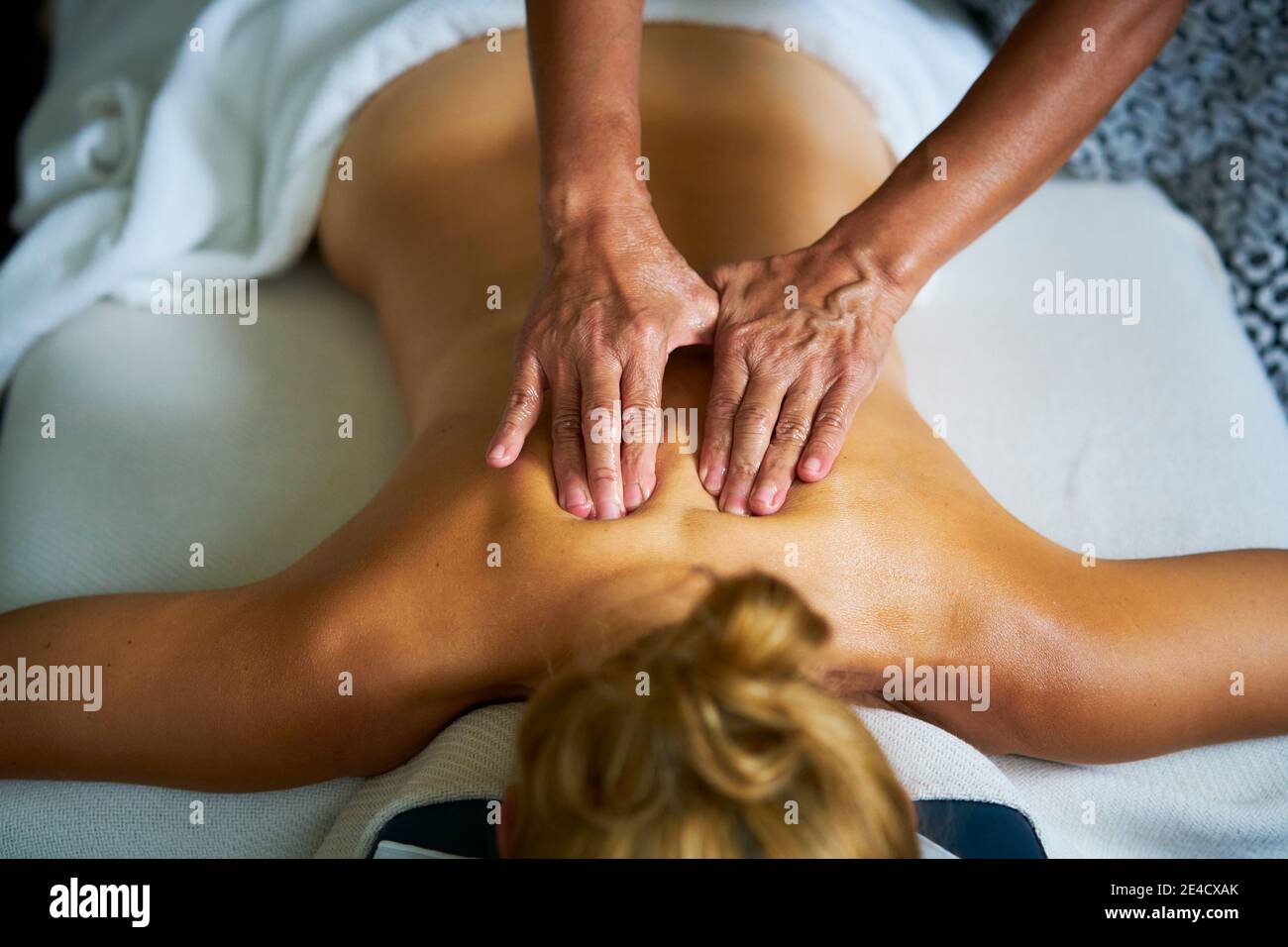 Une femme recevant un massage complet d'huile de corps par un masseuse professionnelle Banque D'Images