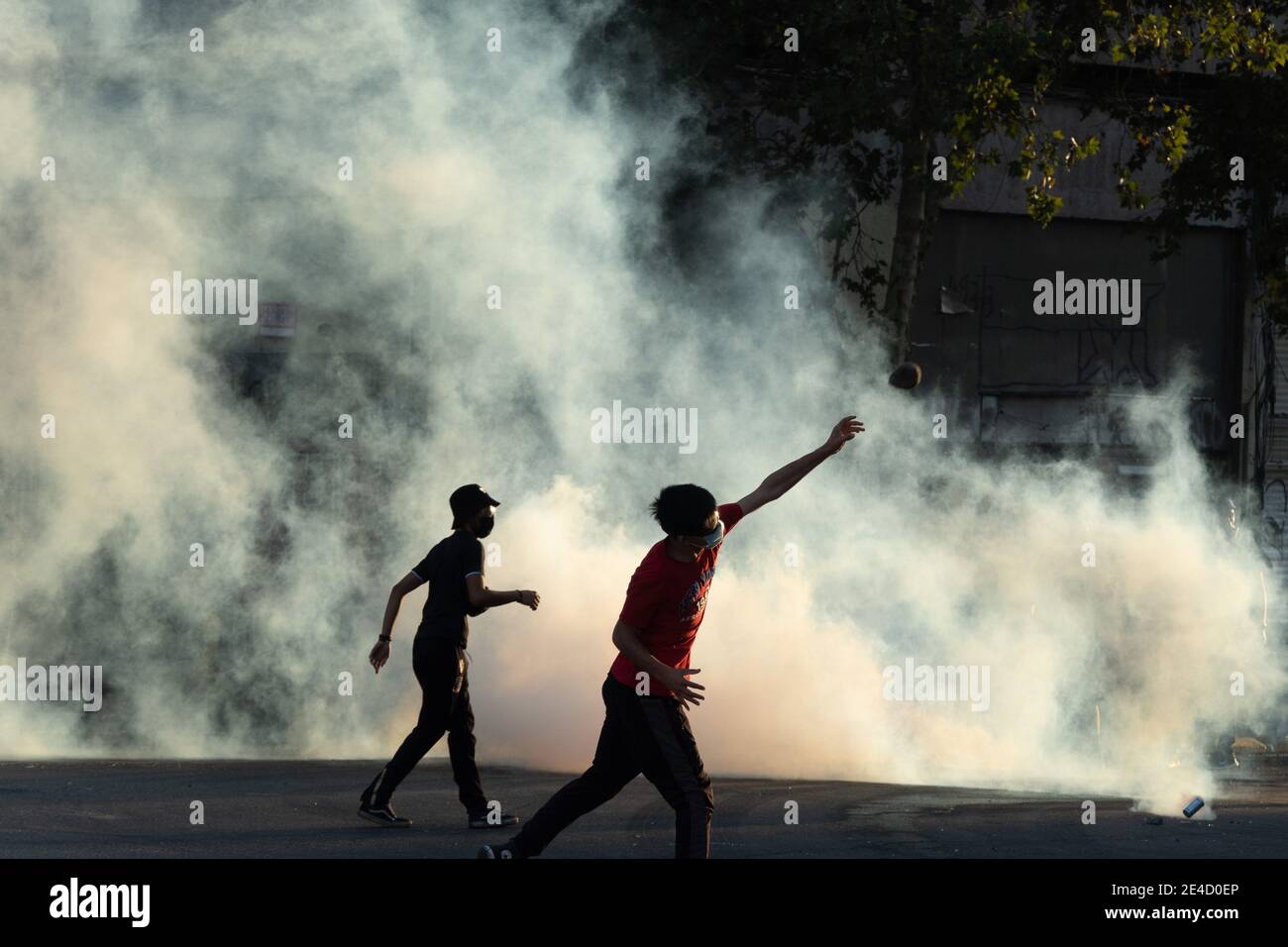 Santiago, Metropolitana, Chili. 22 janvier 2021. Un manifestant jette une pierre à la police, au milieu de la fumée des bombes lacrymogènes, dans un nouveau jour de protestations contre le gouvernement Piñera, dans le centre de Santiago. Credit: Matias Basualdo/ZUMA Wire/Alamy Live News Banque D'Images