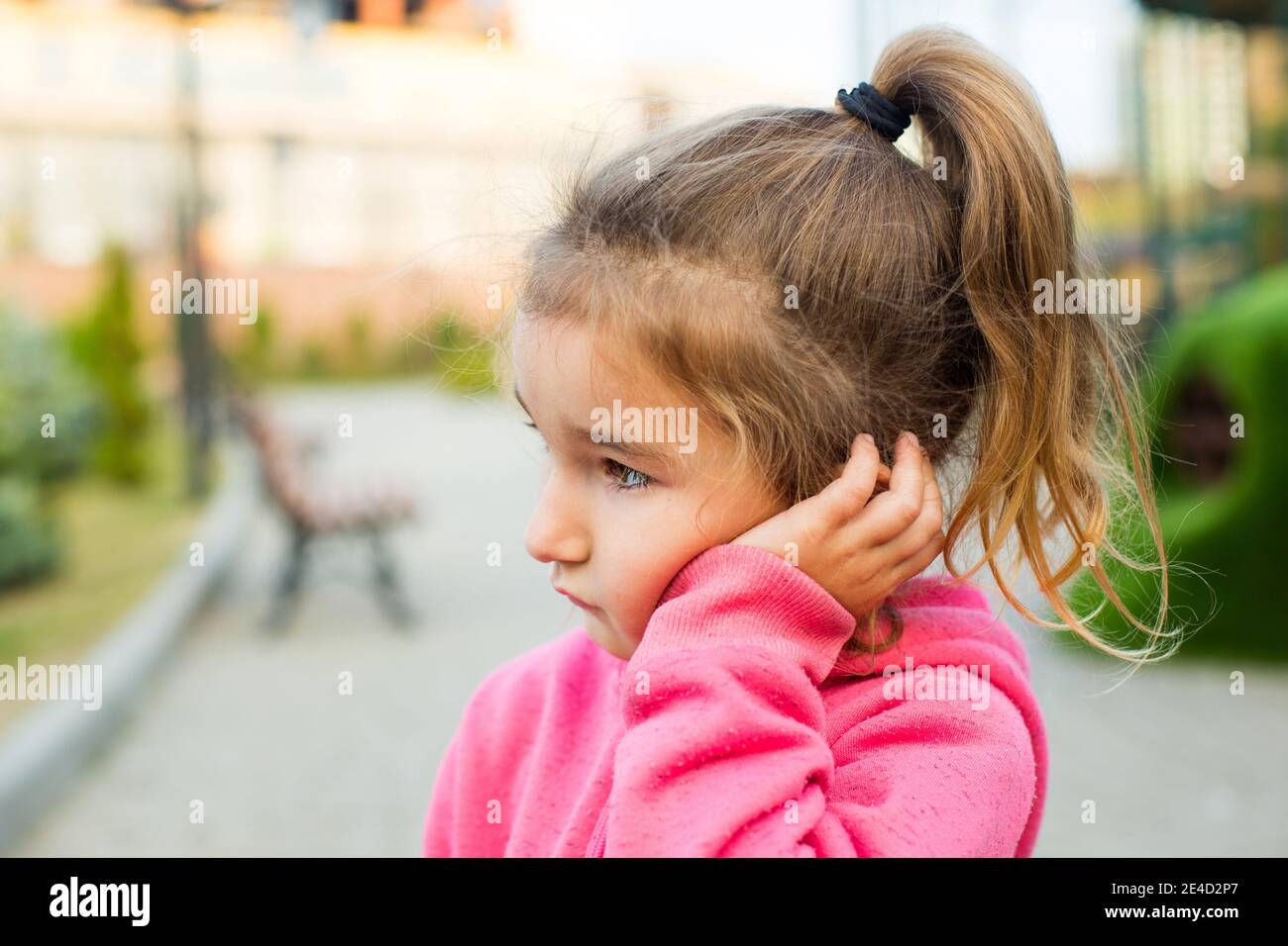 Une petite fille avec un visage triste et effrayé tient sa joue avec sa  main - une dent fait mal. Douleurs à l'oreille, maux de dents, joues et  gencives gonflées, problèmes de