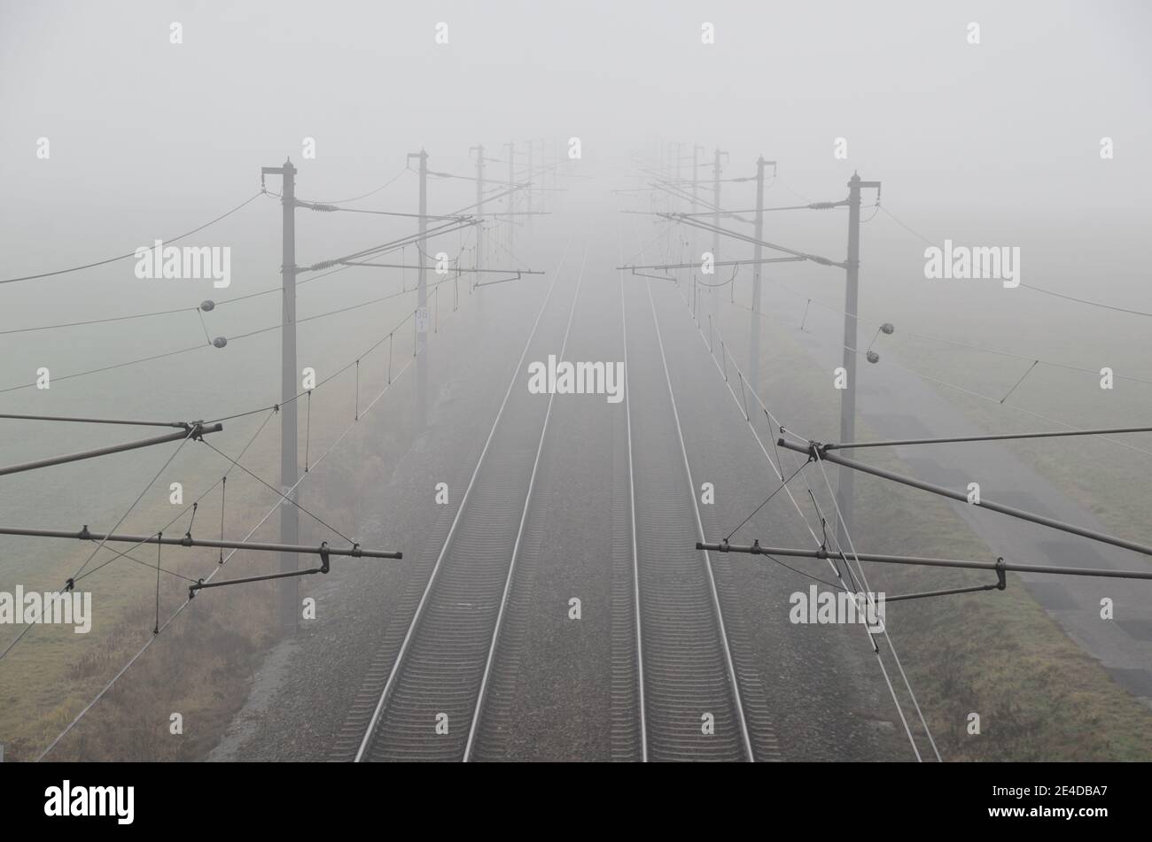 train et rails dans un brouillard dense Banque D'Images