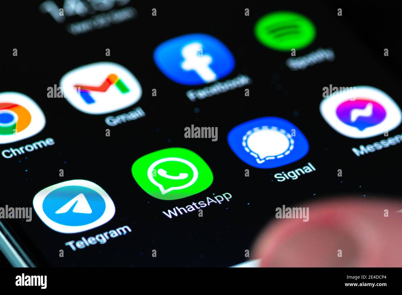 Application WhatsApp avec signal, Messenger et application Telegram affichées sur le smartphone avec le doigt Banque D'Images