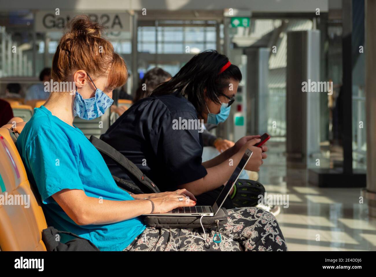 Bangkok, Thaïlande - 23 janvier 2021 : jeune femme caucasienne voyageur portant un masque pour protéger le covid-19 ou le coronavirus envoie un e-mail et un travail Banque D'Images