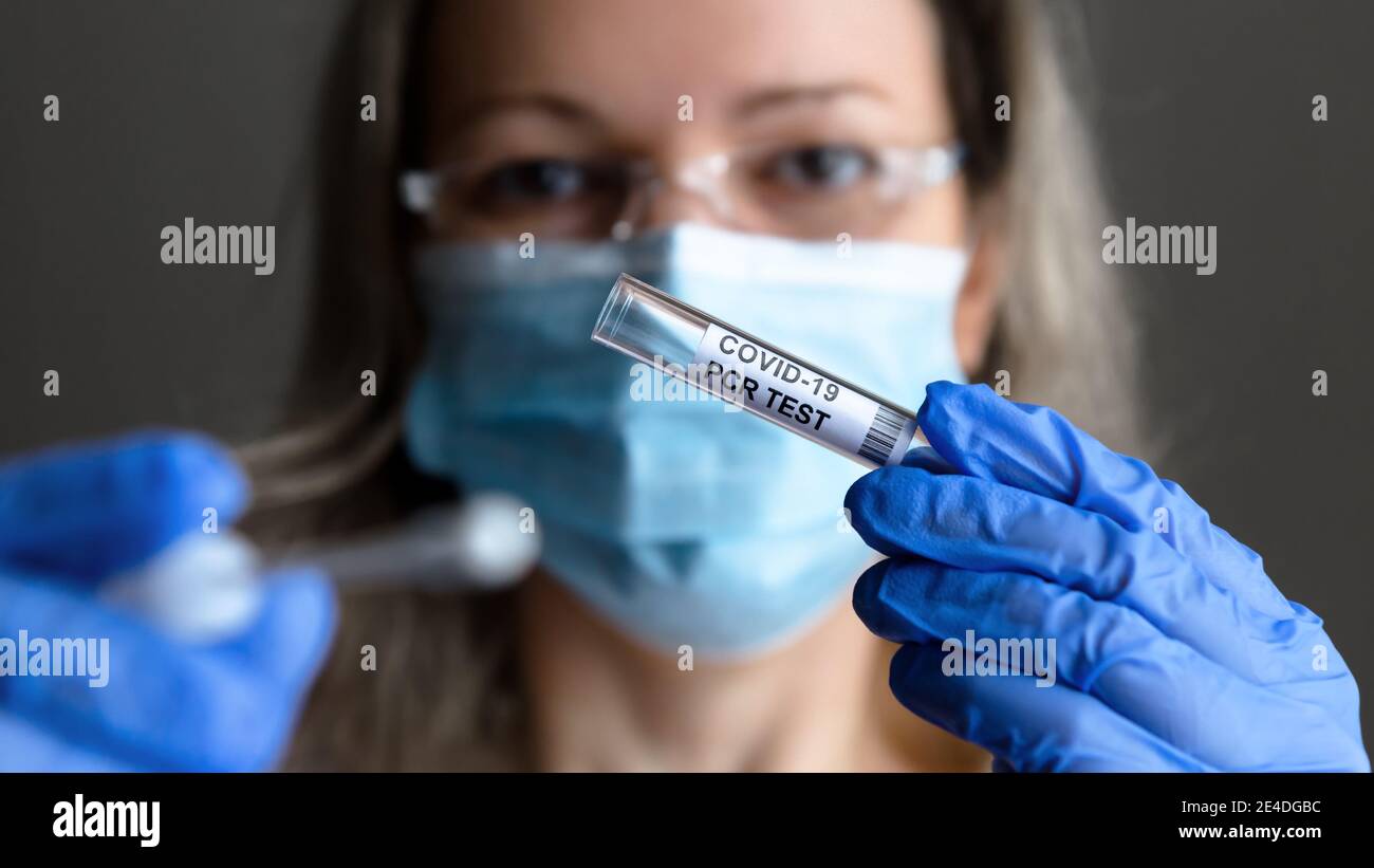 Test COVID-19 dans les mains du médecin de près, la femme en masque médical veut prendre des échantillons de salive et de nez pour le test PCR du coronavirus. Concept de corona vi Banque D'Images