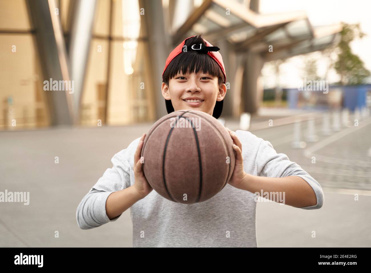 portrait en plein air d'un joyeux joueur asiatique de basket-ball adolescent de 15 ans Banque D'Images