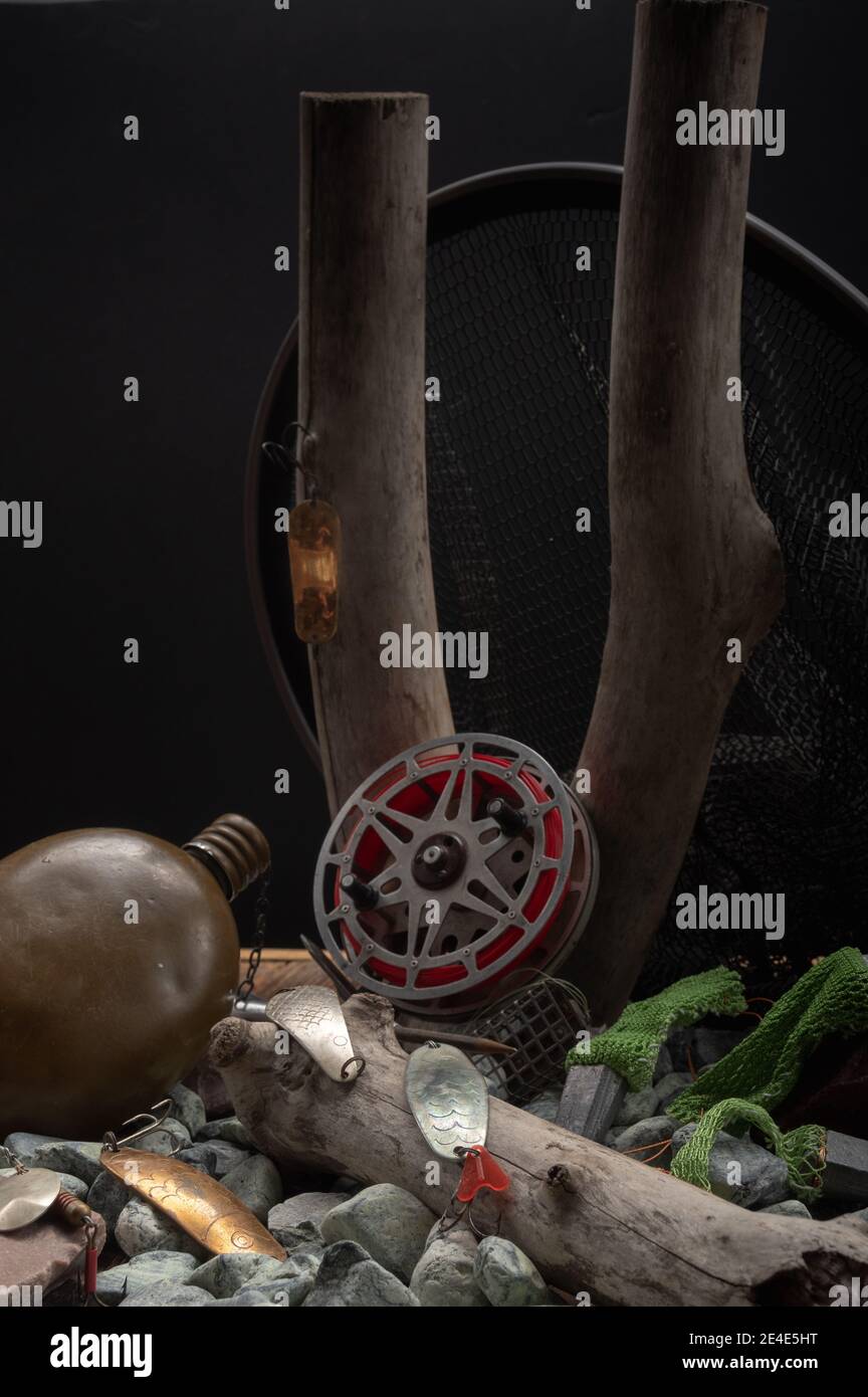 Rouleaux de pêche et boules de fer sur un fond de pierres et de bois. Cadre vertical. Banque D'Images