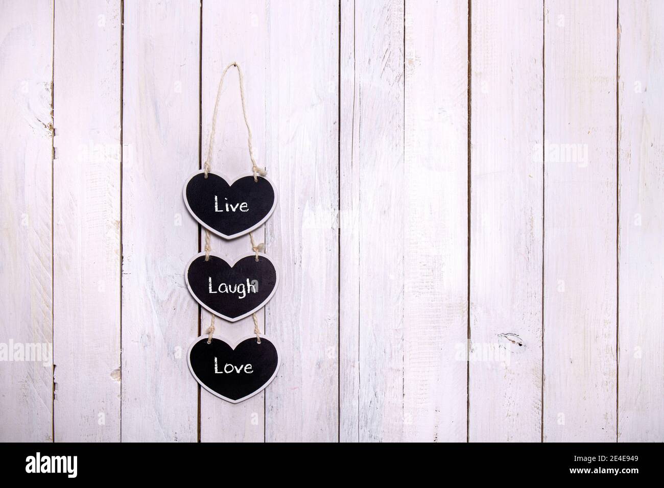 Trois craies en forme de coeur suspendues sur un fond en bois blanc. Écrivez un joli mémo pour votre love.chalkboard suspendu sur un fond en bois blanc Banque D'Images