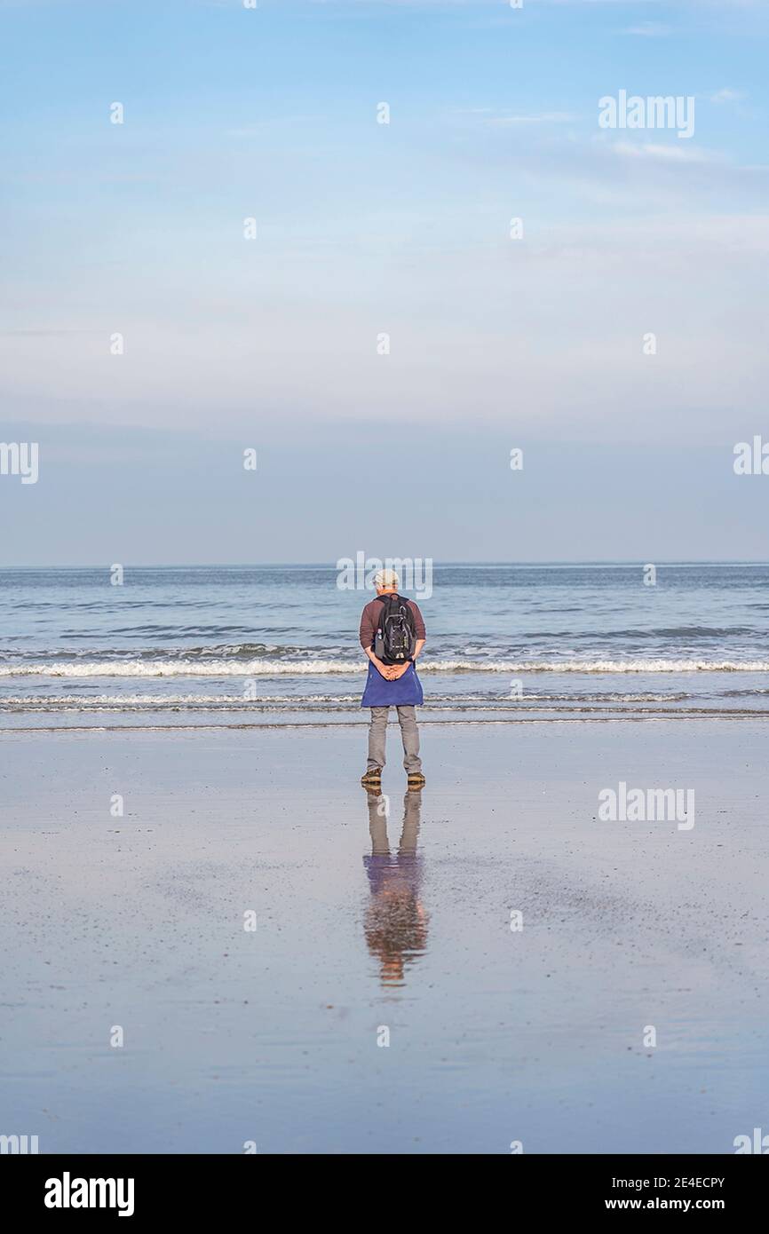 l'homme se tenait sur la plage en pensant au bord de l'eau Banque D'Images