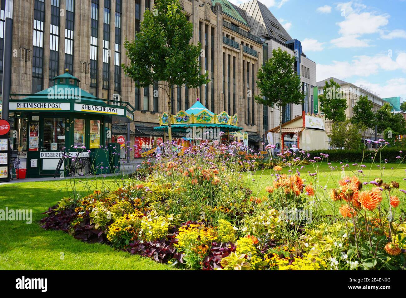 Vue panoramique sur Corneliusplatz dans le centre-ville de Düsseldorf avec kiosque à journaux et carrousel nostalgique en face du bâtiment du grand magasin Kaufhof. Banque D'Images