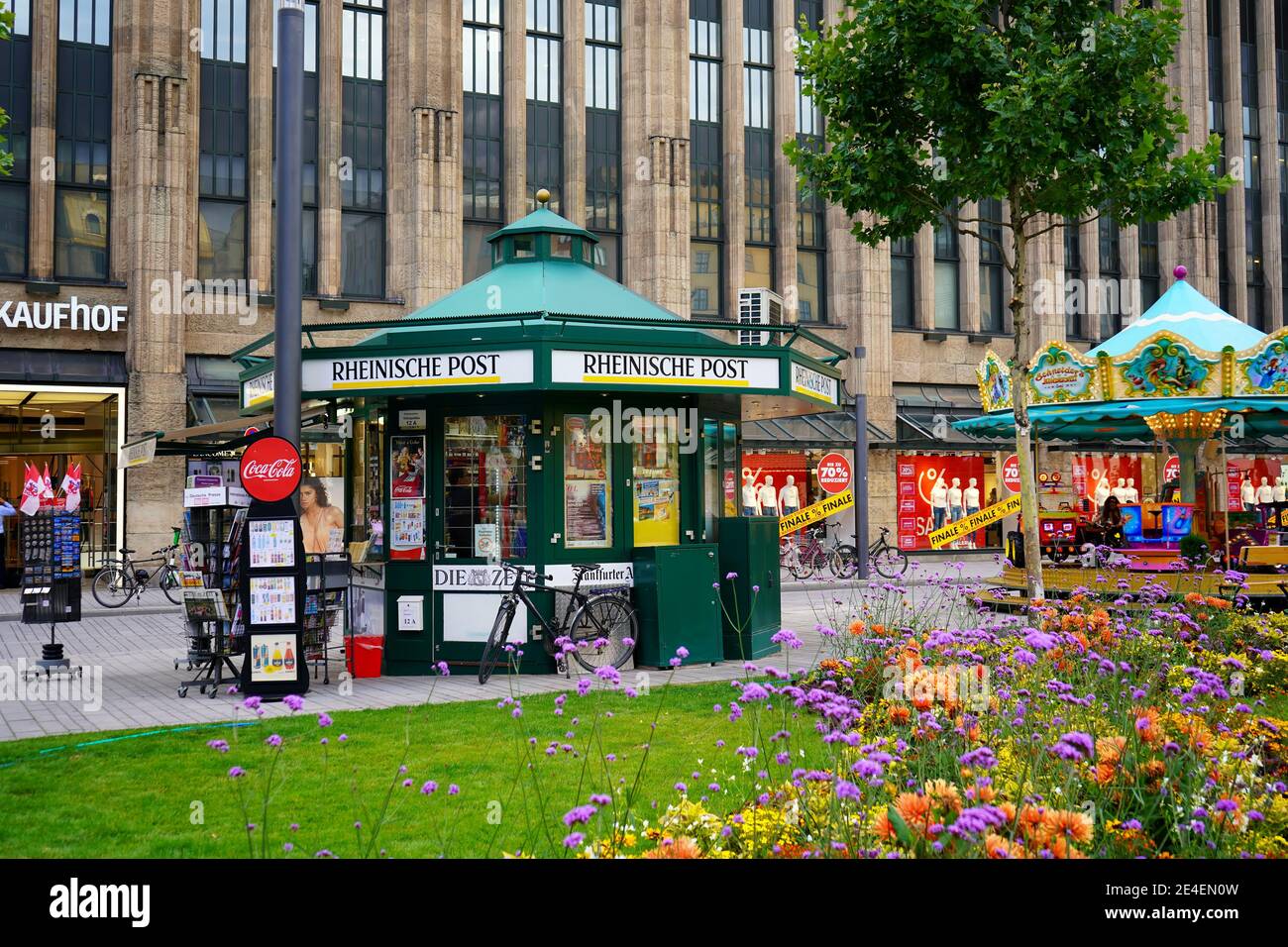 Kiosque à journaux et carrousel d'époque en face du grand magasin Kaufhof à Königsallee lors d'une belle journée d'été. Banque D'Images