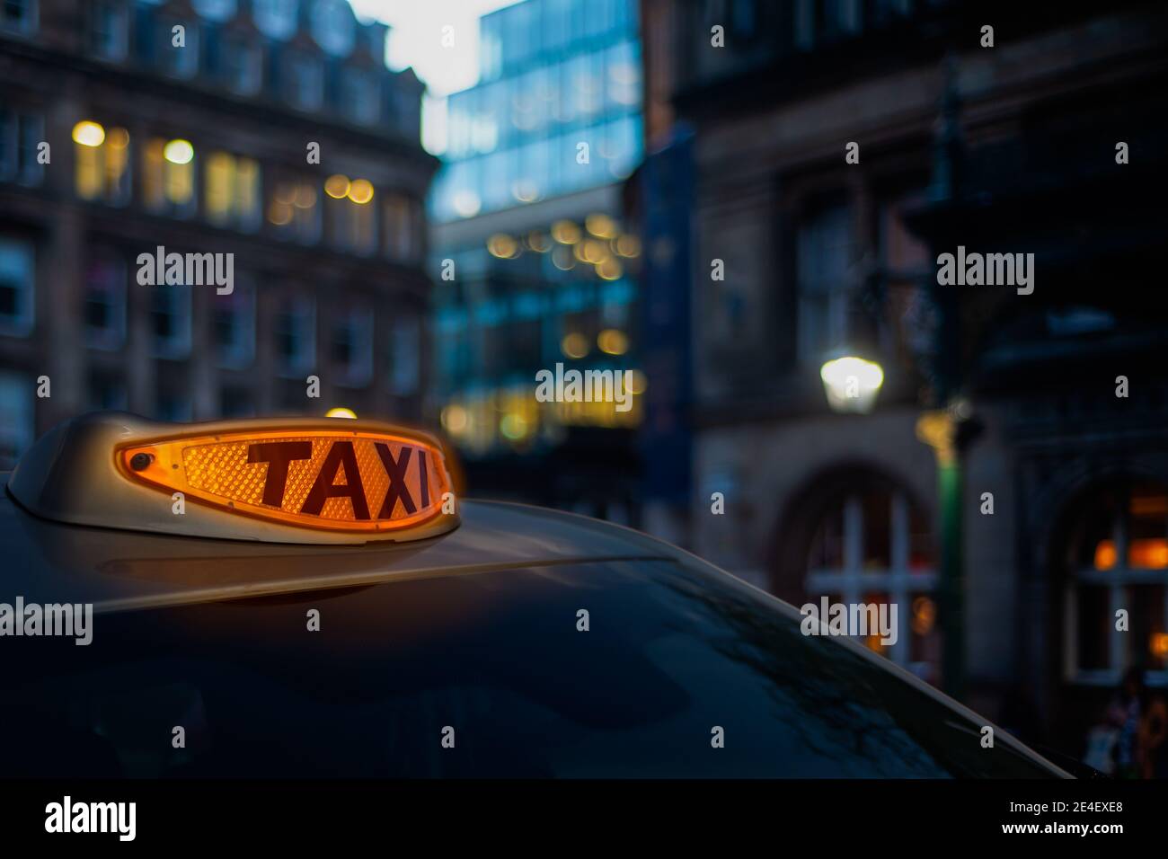 Un feu de taxi orange lumineux dans UNE rue de Londres à Crépuscule Banque D'Images