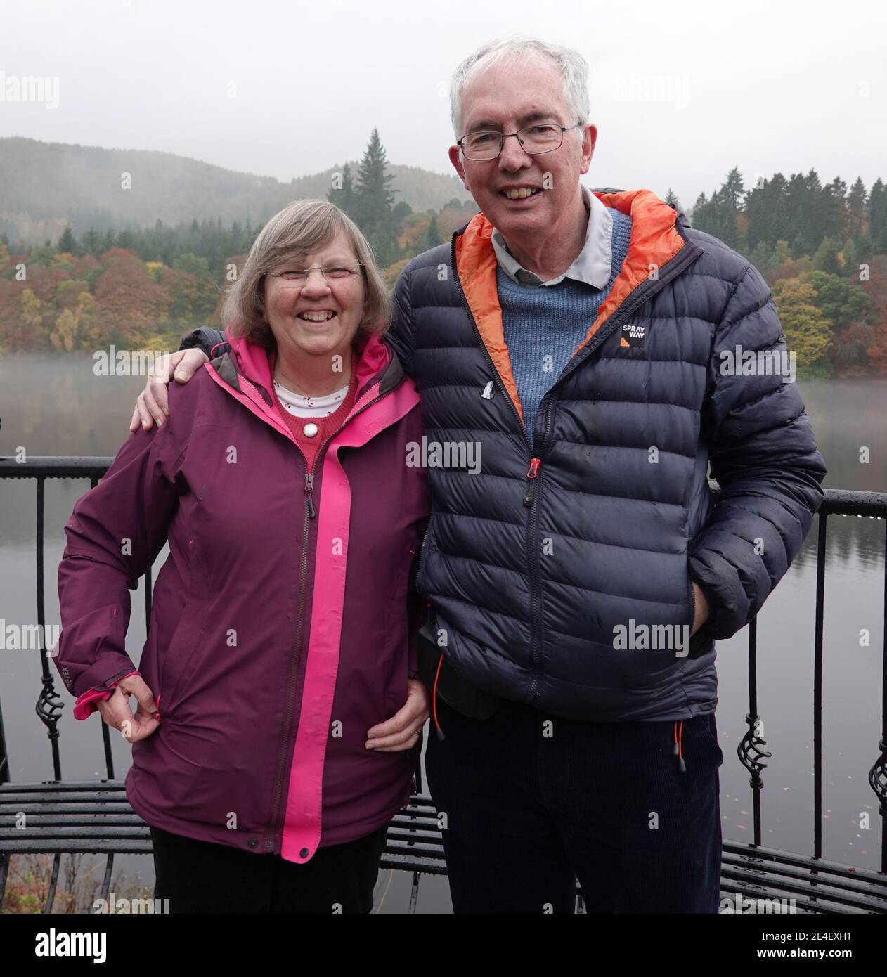 Couple dans leurs années 60 debout avec Loch Faskally derrière Banque D'Images