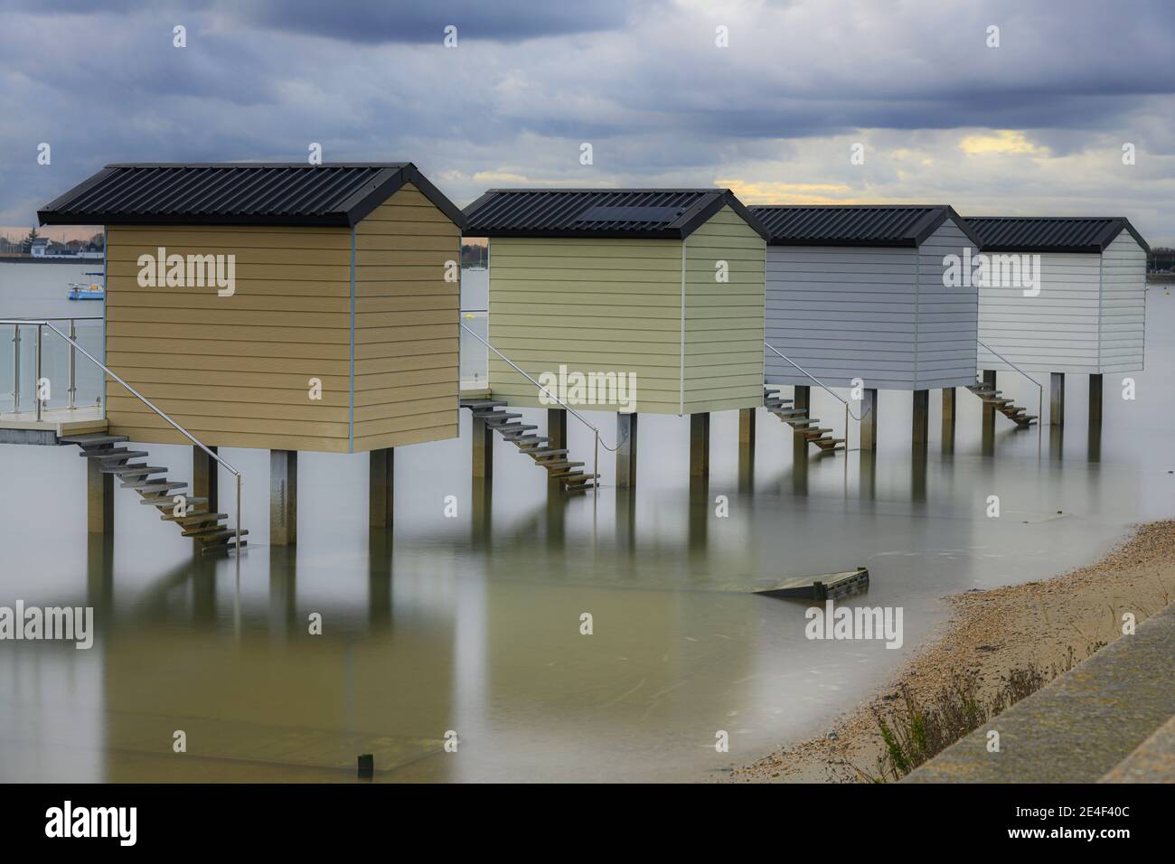 Cabanes de plage à Osea, Essex à marée basse Banque D'Images