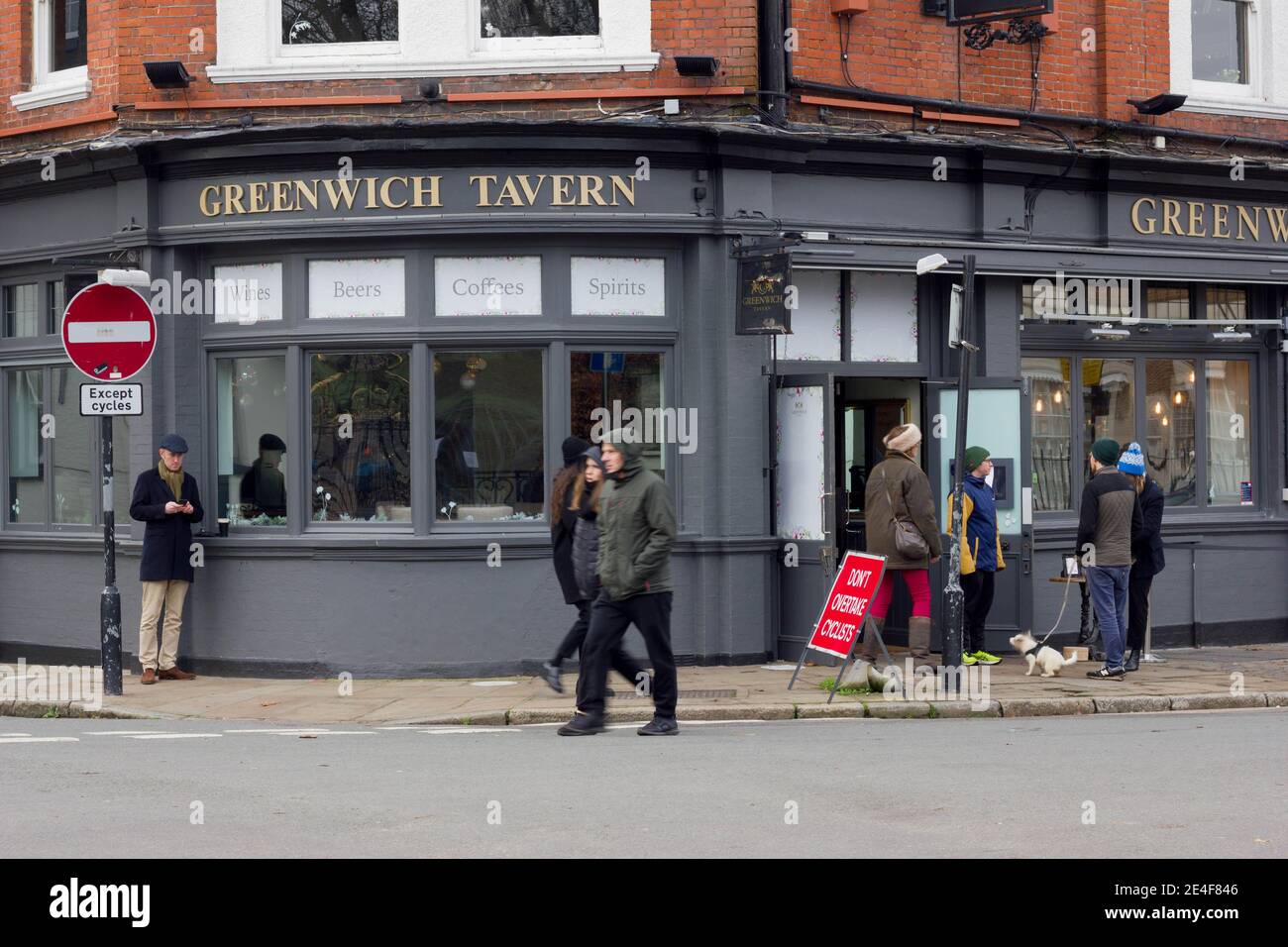 Greenwich taverne bienvenue à emporter clients à l'entrée, homme ayant une pinte de Guinness debout à l'extérieur de Londres Banque D'Images