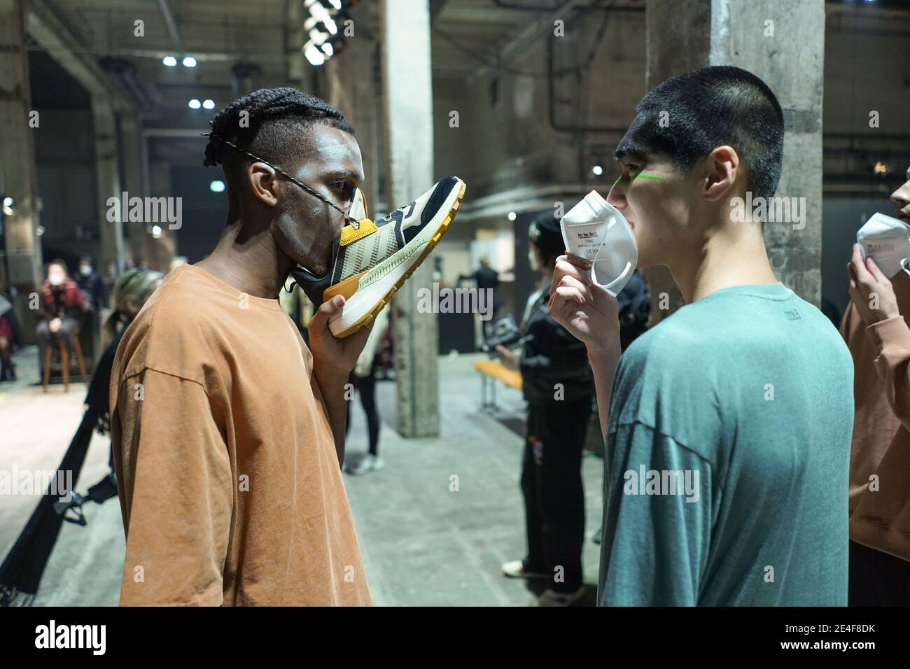 Berlin, Allemagne. 23 janvier 2021. Un modèle porte une sneaker comme un protecteur de bouche pendant la semaine de la mode About You à Kraftwerk. Cette fois-ci, la semaine de la mode de Berlin a lieu sur Internet, les spectacles sont montrés en ligne en raison de la pandémie. Credit: Jörg Carstensen/dpa/Alay Live News Banque D'Images