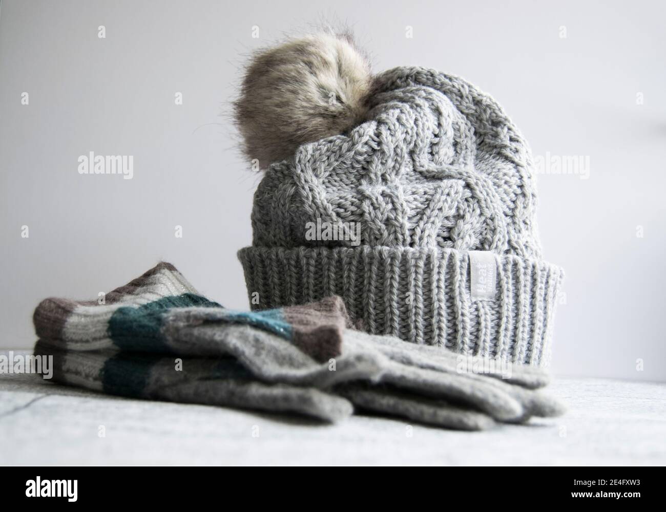 Chapeau de galet en maille torsadée grise confortable avec gants Banque D'Images