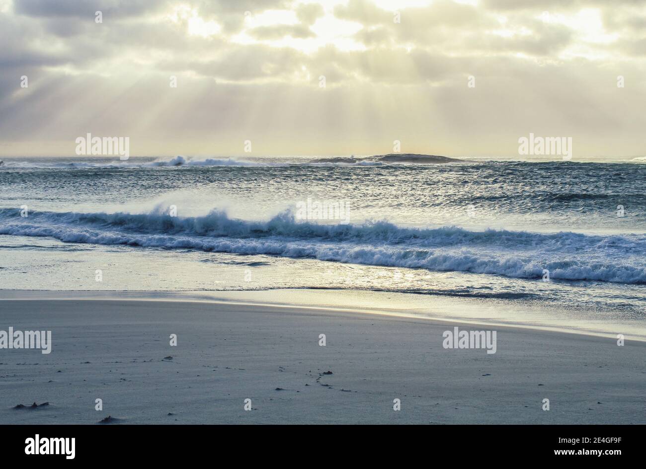 Vagues s'écrasant sur la plage lors d'une soirée d'été à camps Bay à Cape Town, Afrique du Sud Banque D'Images