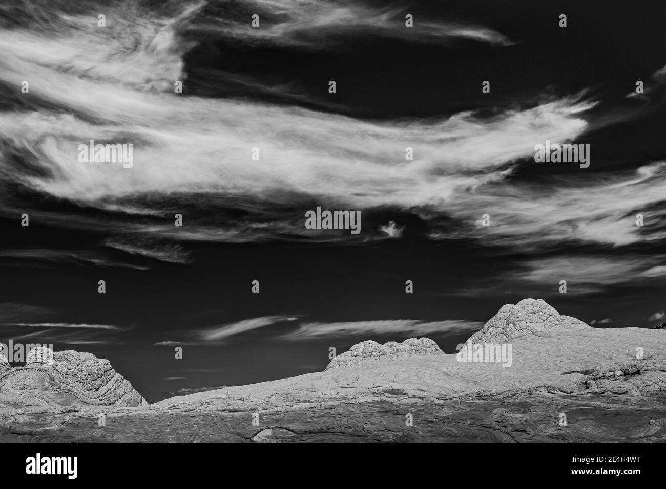 Les nuages de Cirrus au-dessus du grès Navajo se sont fissurés et érodés en polygones, à White Pocket, monument national de Vermilion Cliffs, Arizona, États-Unis Banque D'Images