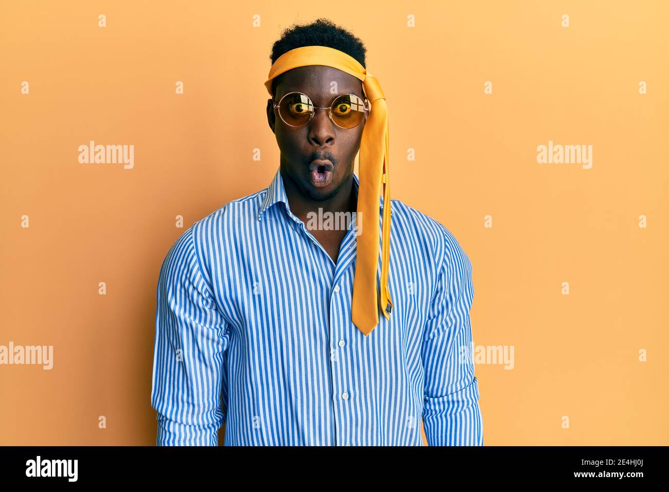Beau homme noir ivre portant cravate sur la tête et lunettes de soleil peur  et choqué avec l'expression surprise, la peur et le visage excité Photo  Stock - Alamy
