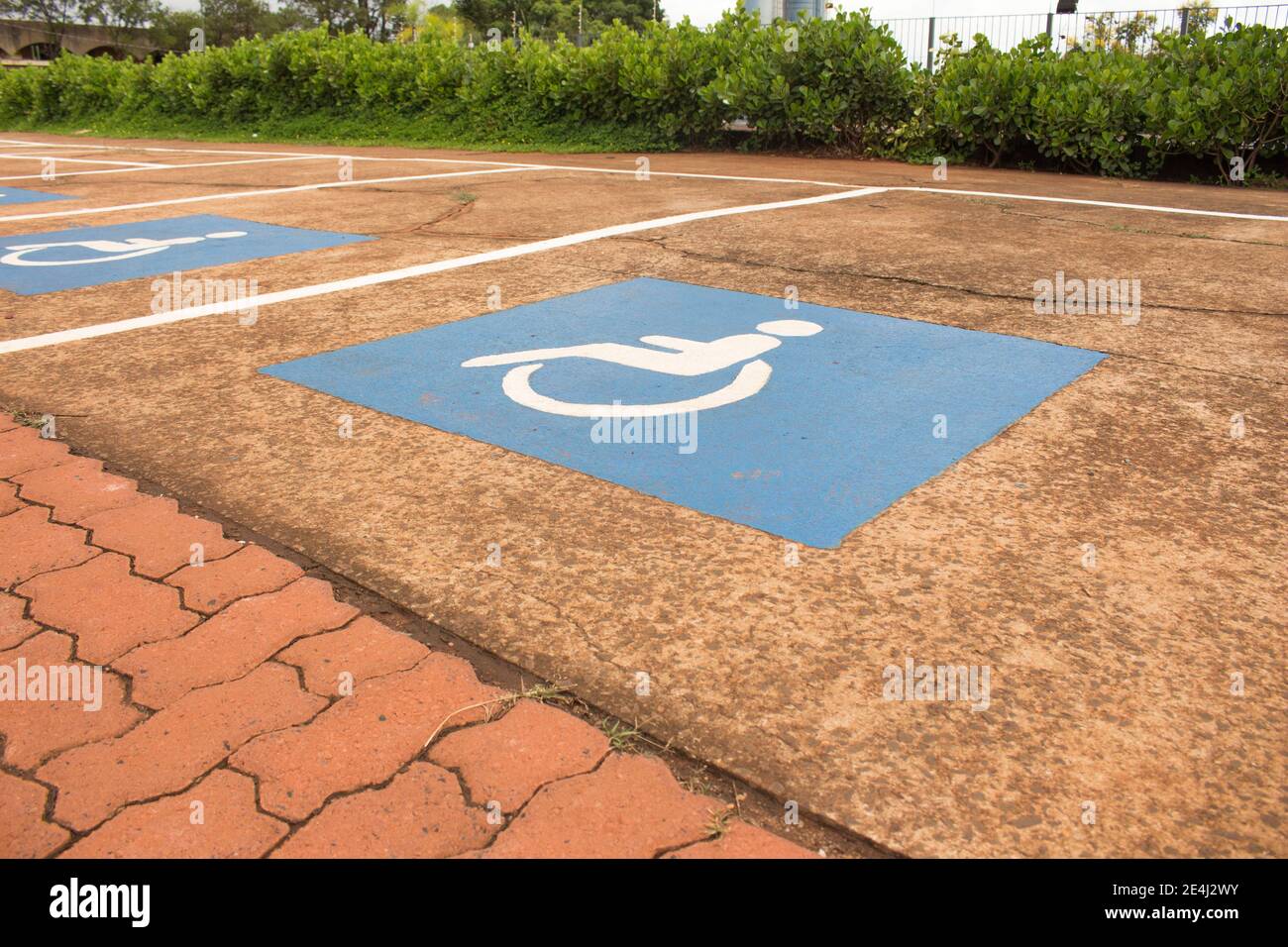 Détail de la place de stationnement pour personnes handicapées sur béton. Panneau bleu et blanc peint sur le plancher Banque D'Images