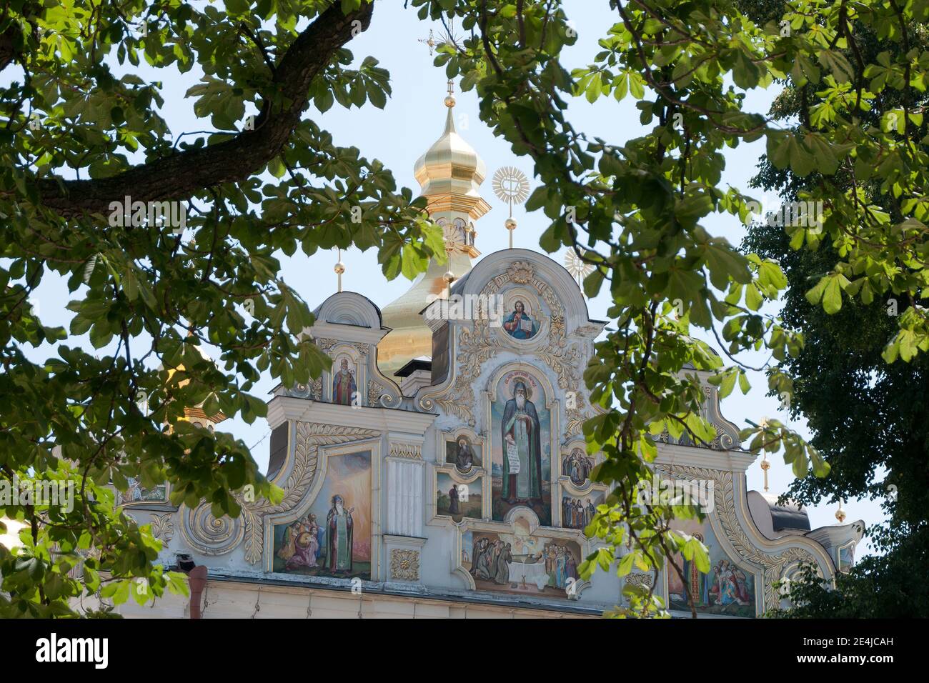 Kiev Ukraine, vue sur les peintures murales du toit de la cathédrale de Dormition décorée de façon ornée à travers les branches d'arbres Banque D'Images