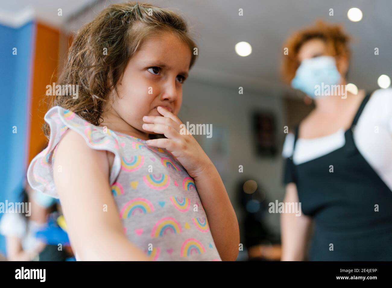 Fille contrariée regardant loin t coiffeur dans le salon de coiffure pendant pandémie Banque D'Images