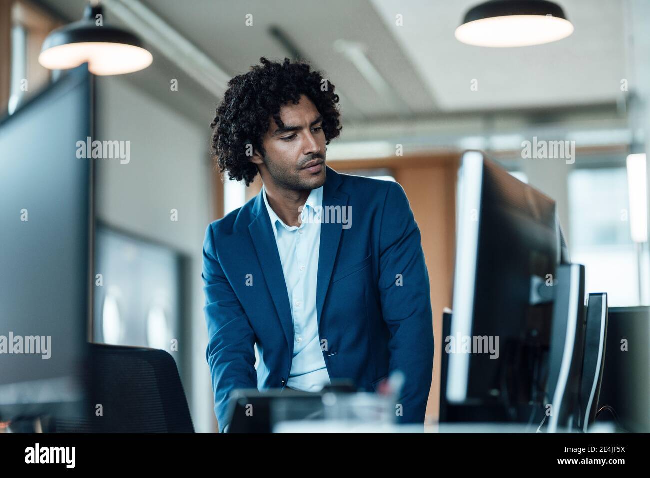 Homme professionnel regardant des moniteurs d'ordinateur dans le bureau Banque D'Images