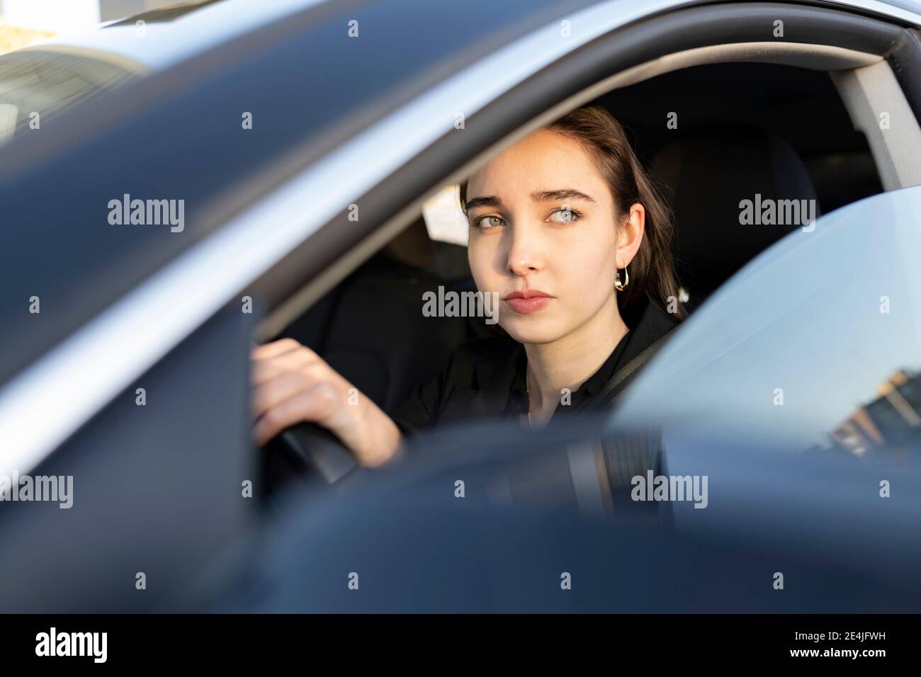 Femme d'affaires regardant loin en conduisant la voiture Banque D'Images