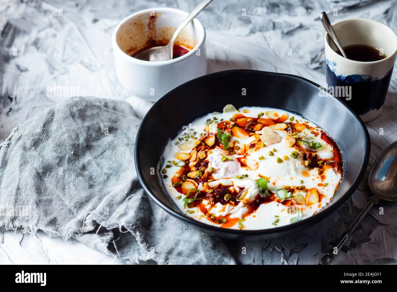 Petit déjeuner aux œufs pochés avec yaourt et beurre de paprika épicé bol sur la table Banque D'Images