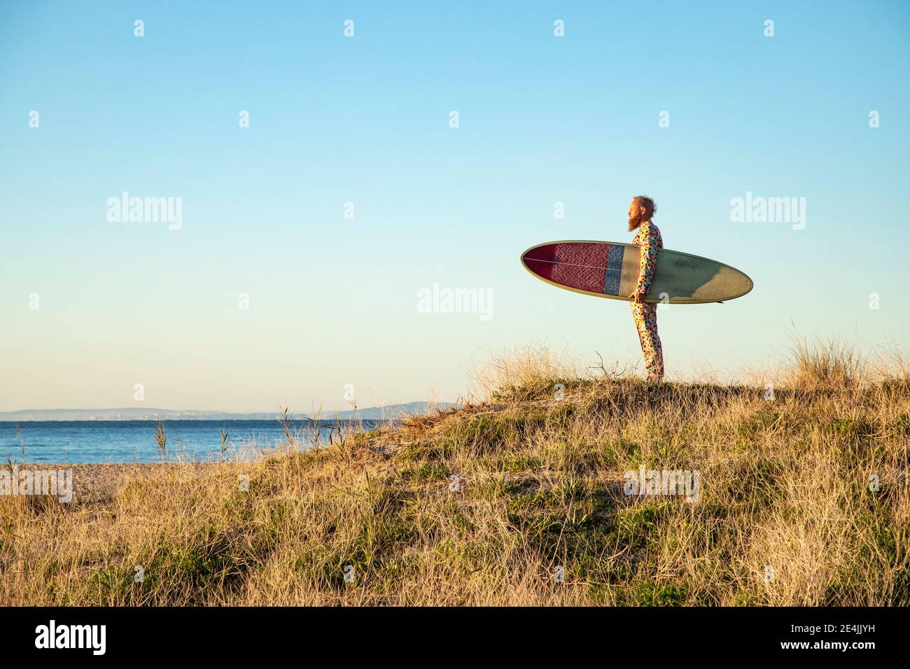 Homme regardant la vue sur la mer en se tenant debout avec la planche de surf plage Banque D'Images