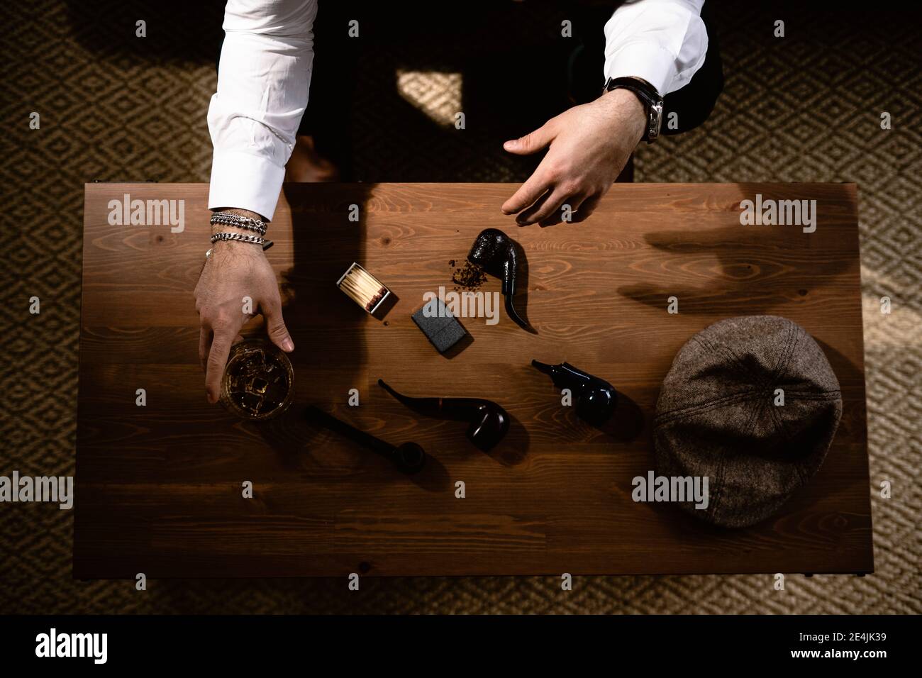 Mains de l'homme préparant le tuyau à la table basse Banque D'Images