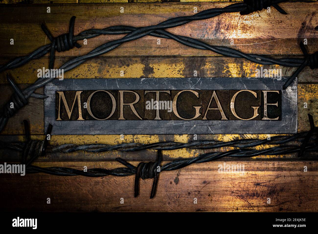 Texte hypothécaire avec fil barbelé sur la barre de plomb grunge texturé et bronze Banque D'Images