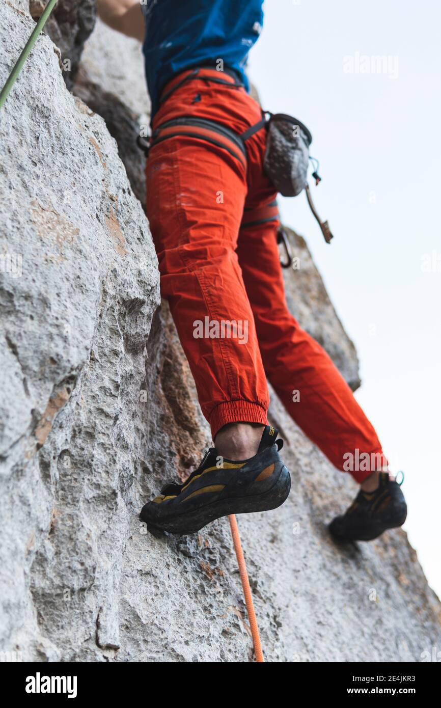 Sportif grimpant sur une montagne rocheuse Banque D'Images