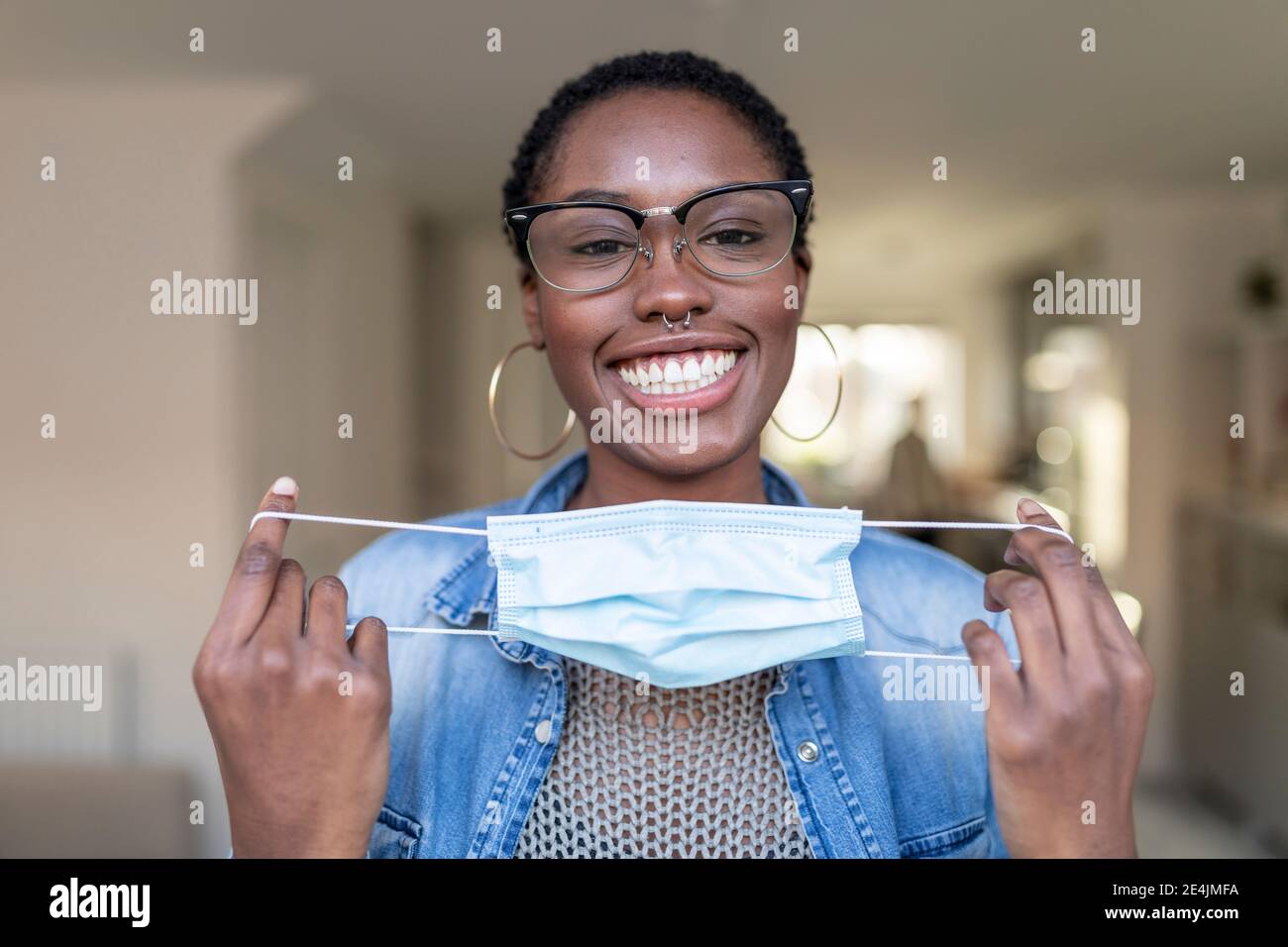 Portrait d'une femme souriante tenant un masque Banque D'Images