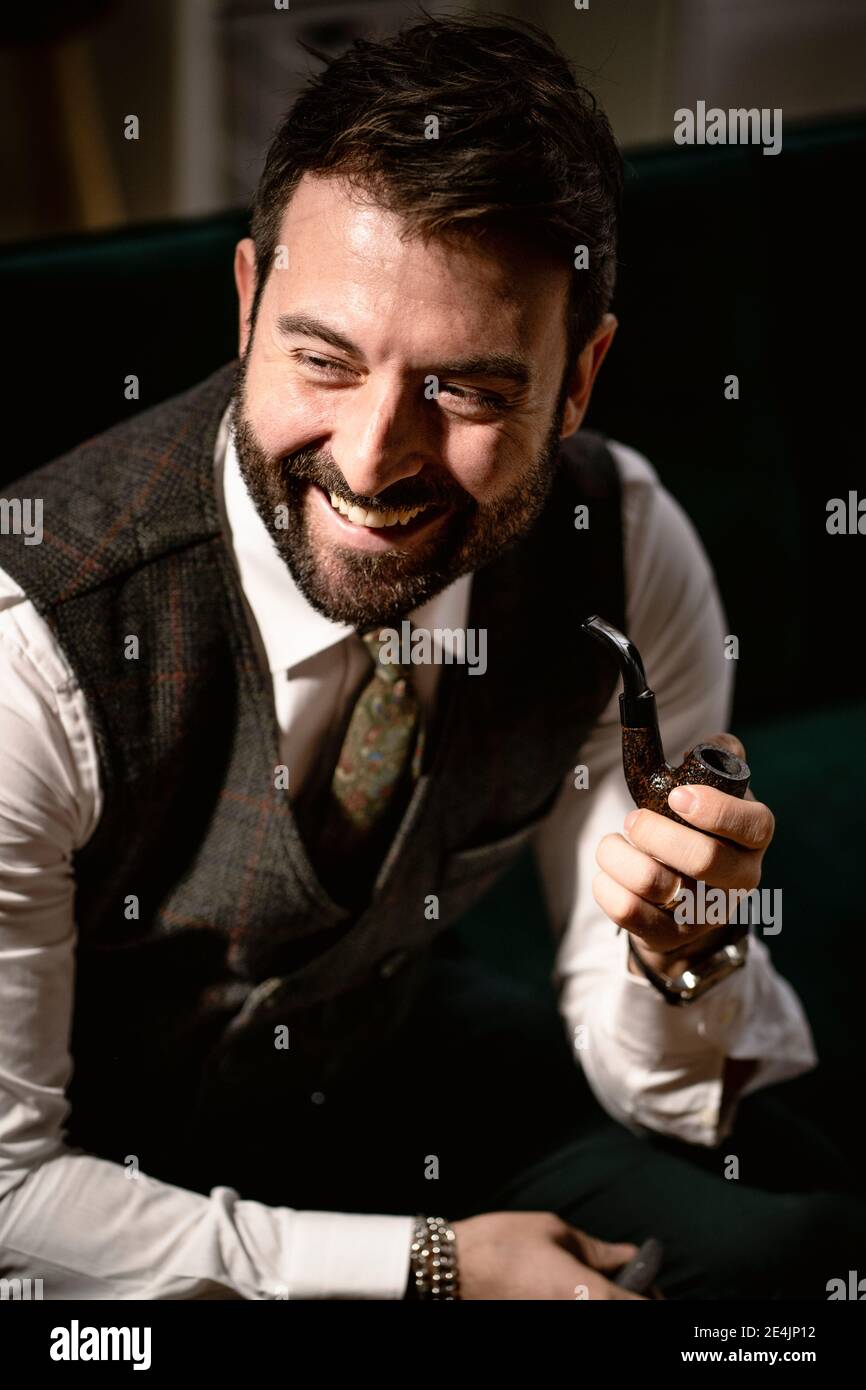 Portrait d'un homme barbu qui rit tout en fugeant du tuyau Banque D'Images