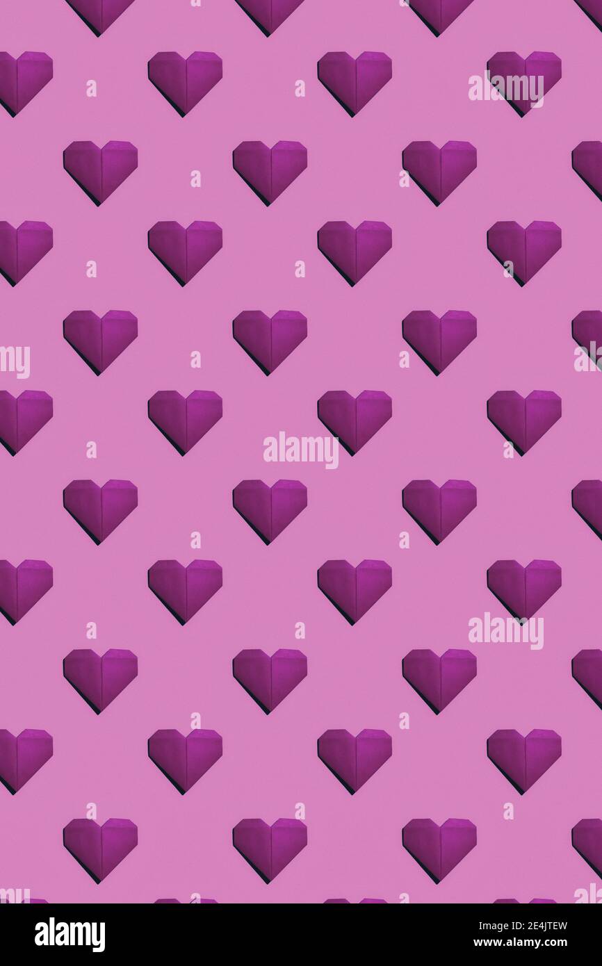 Coeurs de papier magenta sur fond rose Banque D'Images