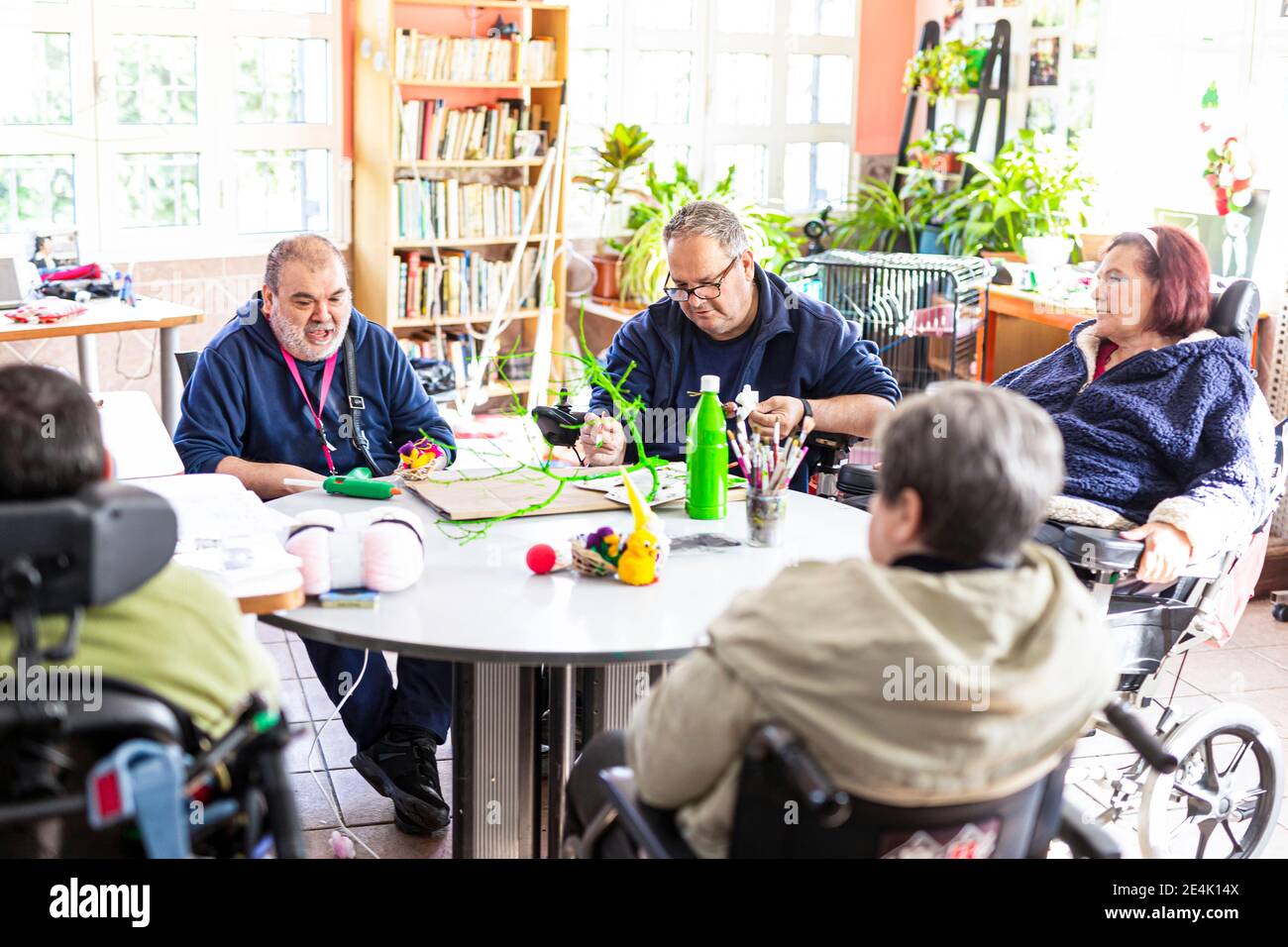 Personnes handicapées faisant l'artisanat à table dans la maison de soins infirmiers Banque D'Images