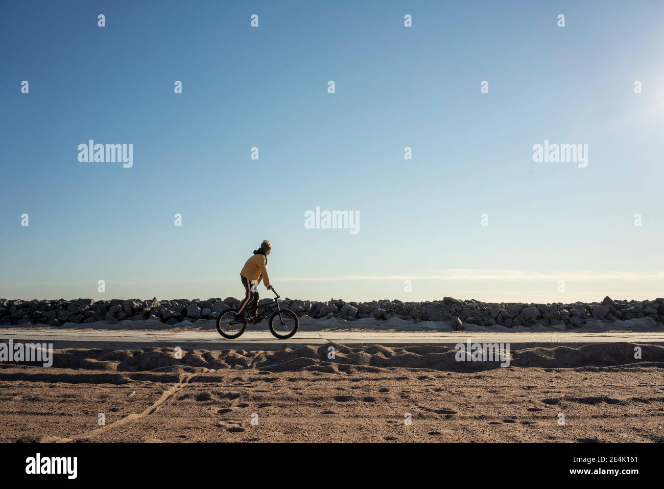 Ciel dégagé sur un garçon en longeant une route vide Banque D'Images