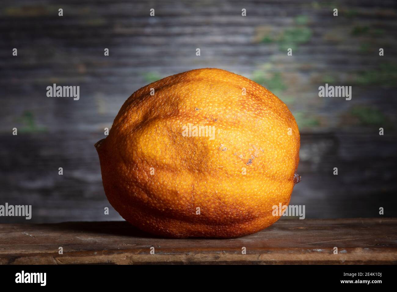 Un citron sec en lumière vive sur fond de bois, .Macro Shot. Photo de la vie fixe minimale Banque D'Images
