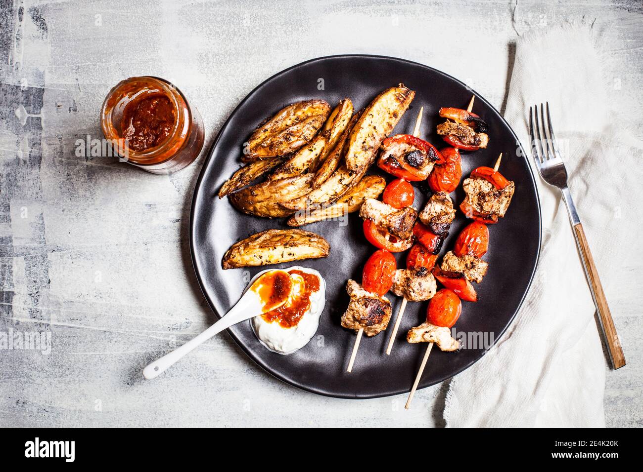 Brochettes de poulet Gyros avec tomates, poivrons, quartiers de pommes de terre et tzatziki sur la table Banque D'Images