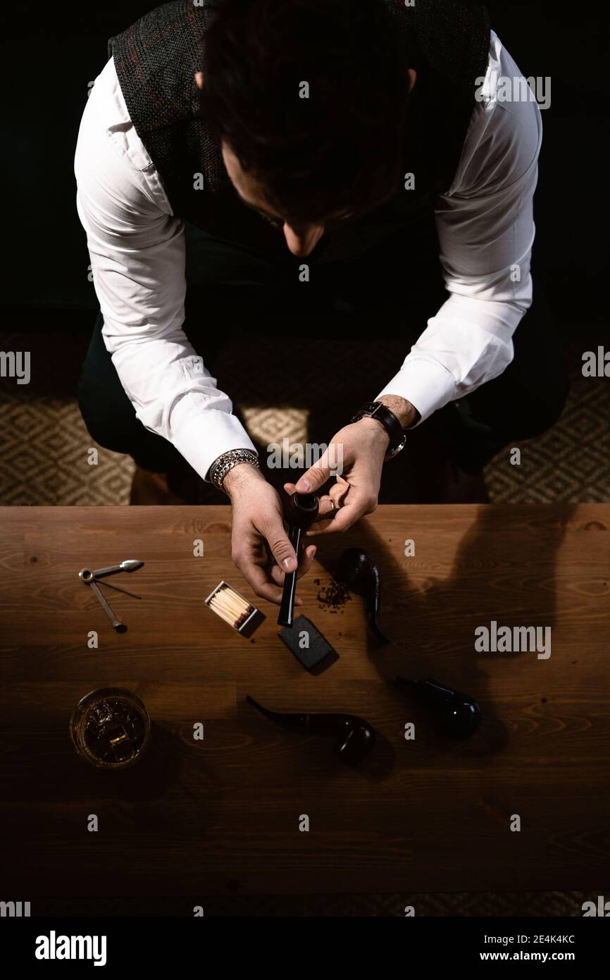 Homme préparant le tuyau à la table basse Banque D'Images