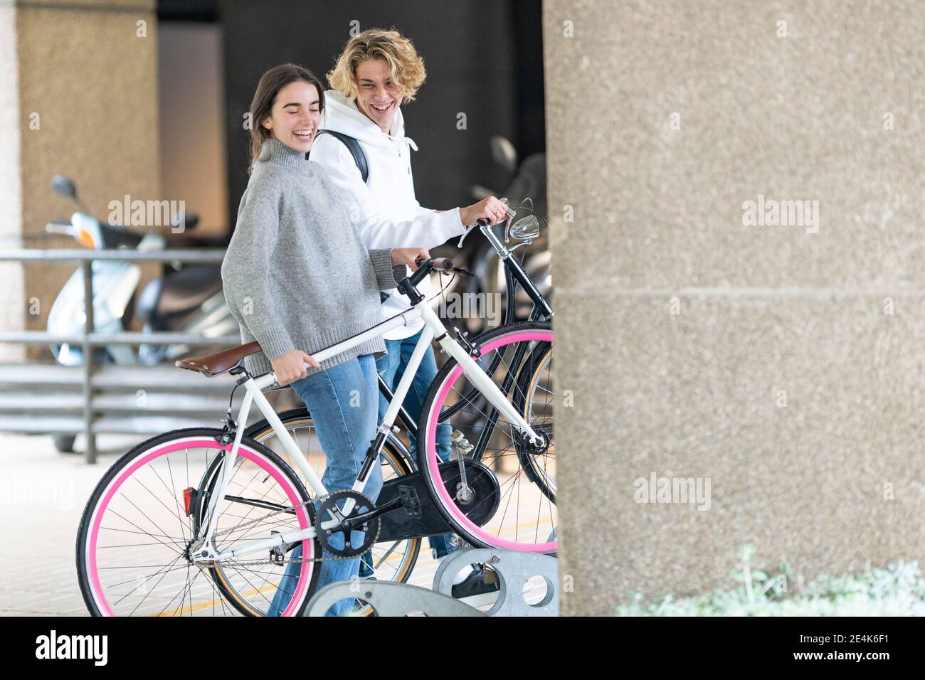 Des amis heureux avec un vélo sur le parking Banque D'Images