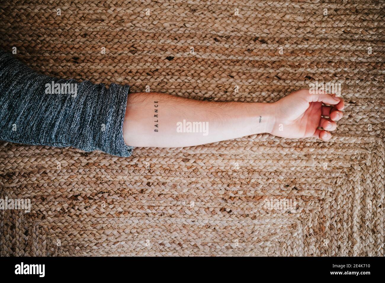 Homme avec équilibre texte tatouage main sur le sol Banque D'Images