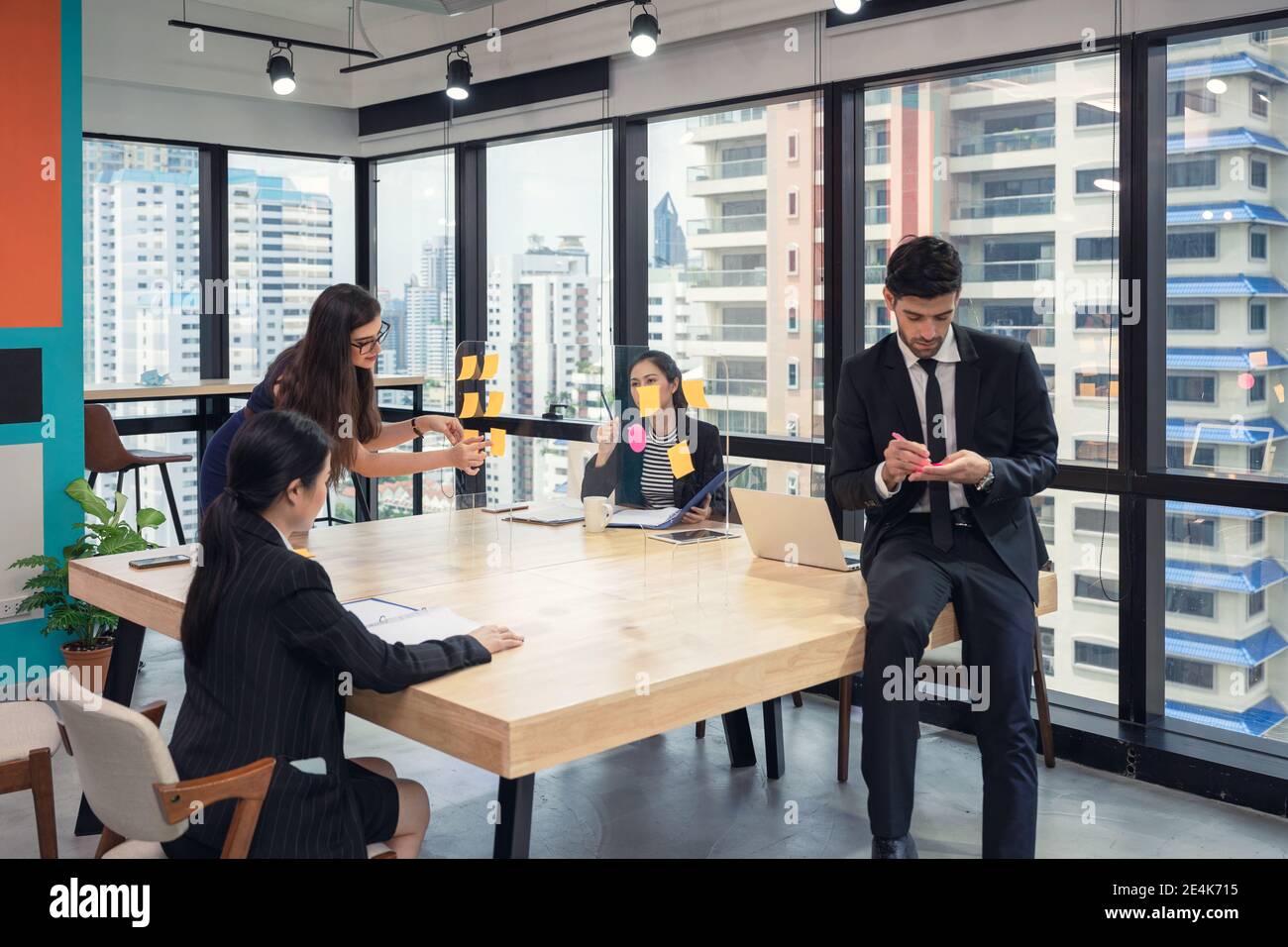 Équipe d'affaires multiethnique en brainstorming avec des post-it collés sur un tableau de conférence dans un espace de coworking dans le quartier des affaires Banque D'Images