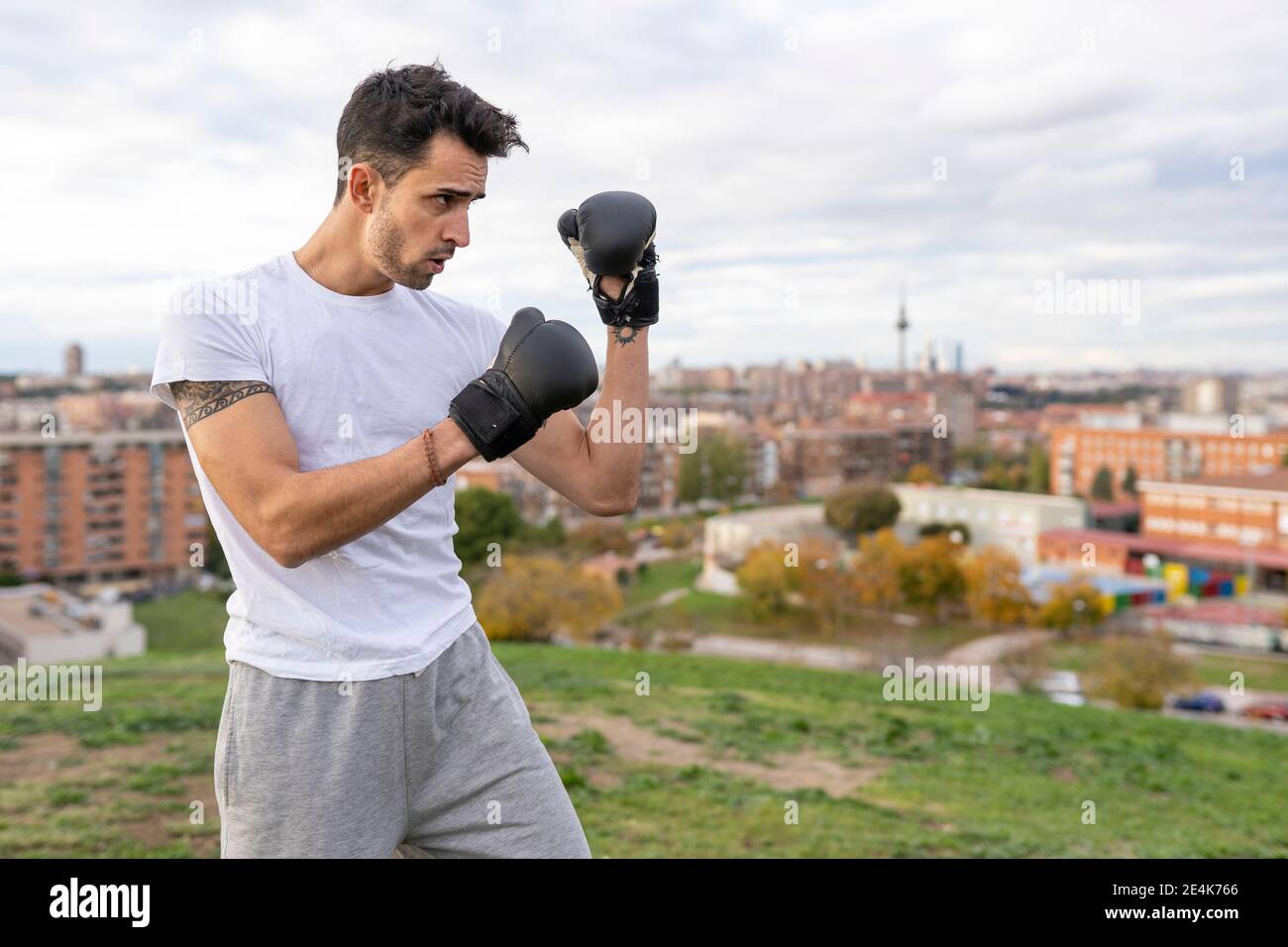 Homme acrobat pratiquant la boxe sur la colline dans la ville Banque D'Images Homme acrobat pratiquant la boxe sur la colline dans la ville Banque D'Images