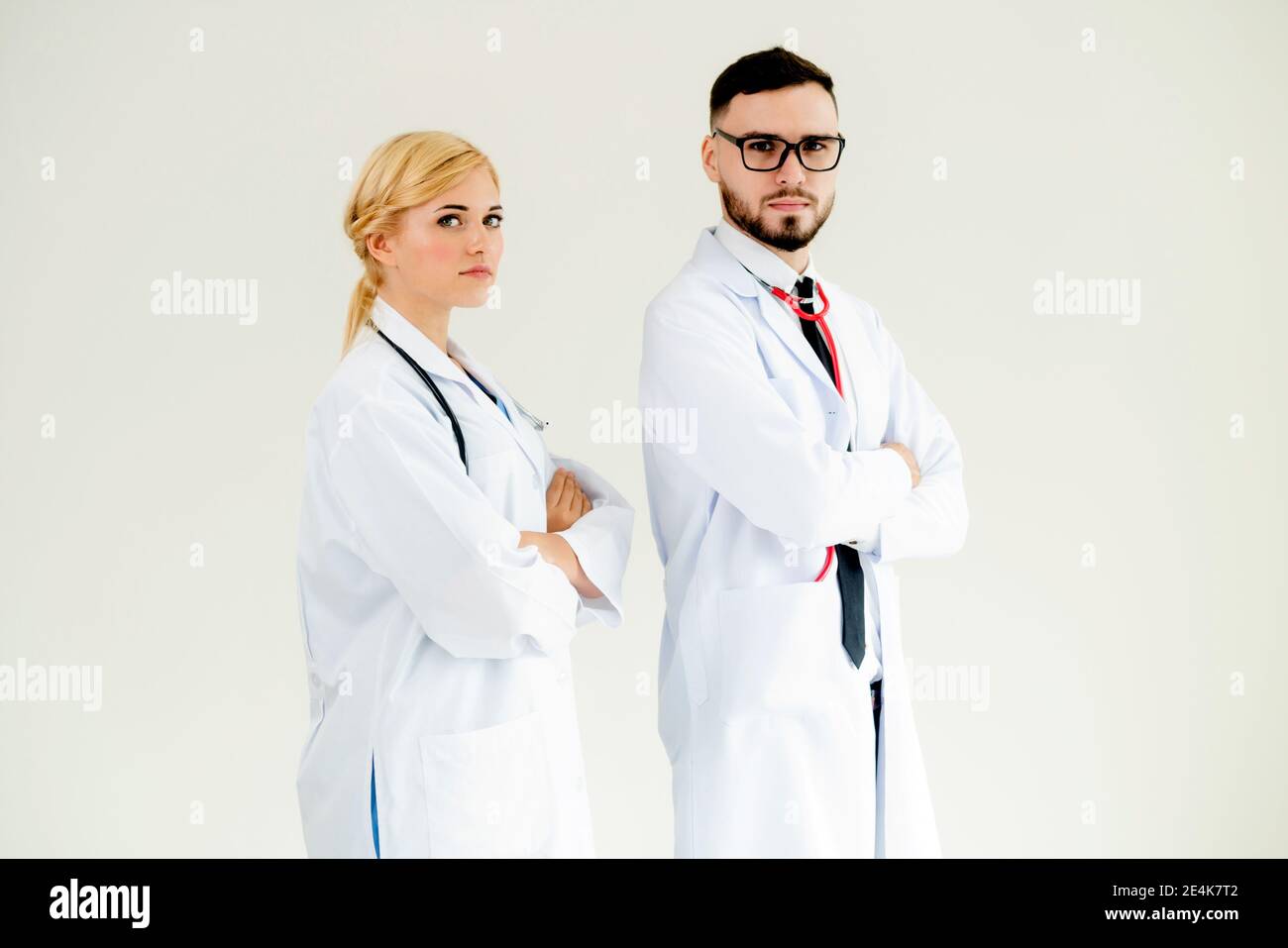 Confident doctors standing sur fond blanc avec les bras croisés. Concept de l'équipe de soins médicaux professionnels. Banque D'Images