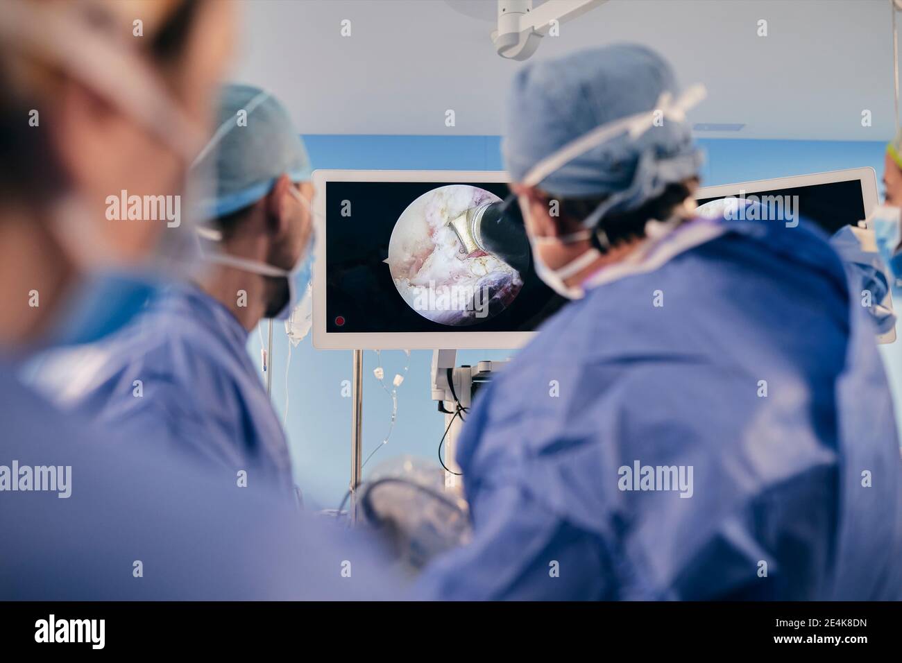 Professionnels qui surveillent la chirurgie sur écran d'ordinateur tout en étant debout chambre Banque D'Images