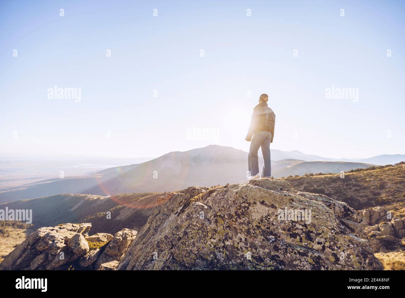 Randonneur femelle debout sur le sommet de la montagne contre le ciel clair par beau temps Banque D'Images